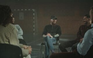 Adults in a support group discussion circle representing structured sober living after rehab in Nampa, Idaho